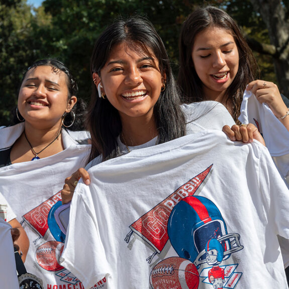 girl holding up decorated shirt